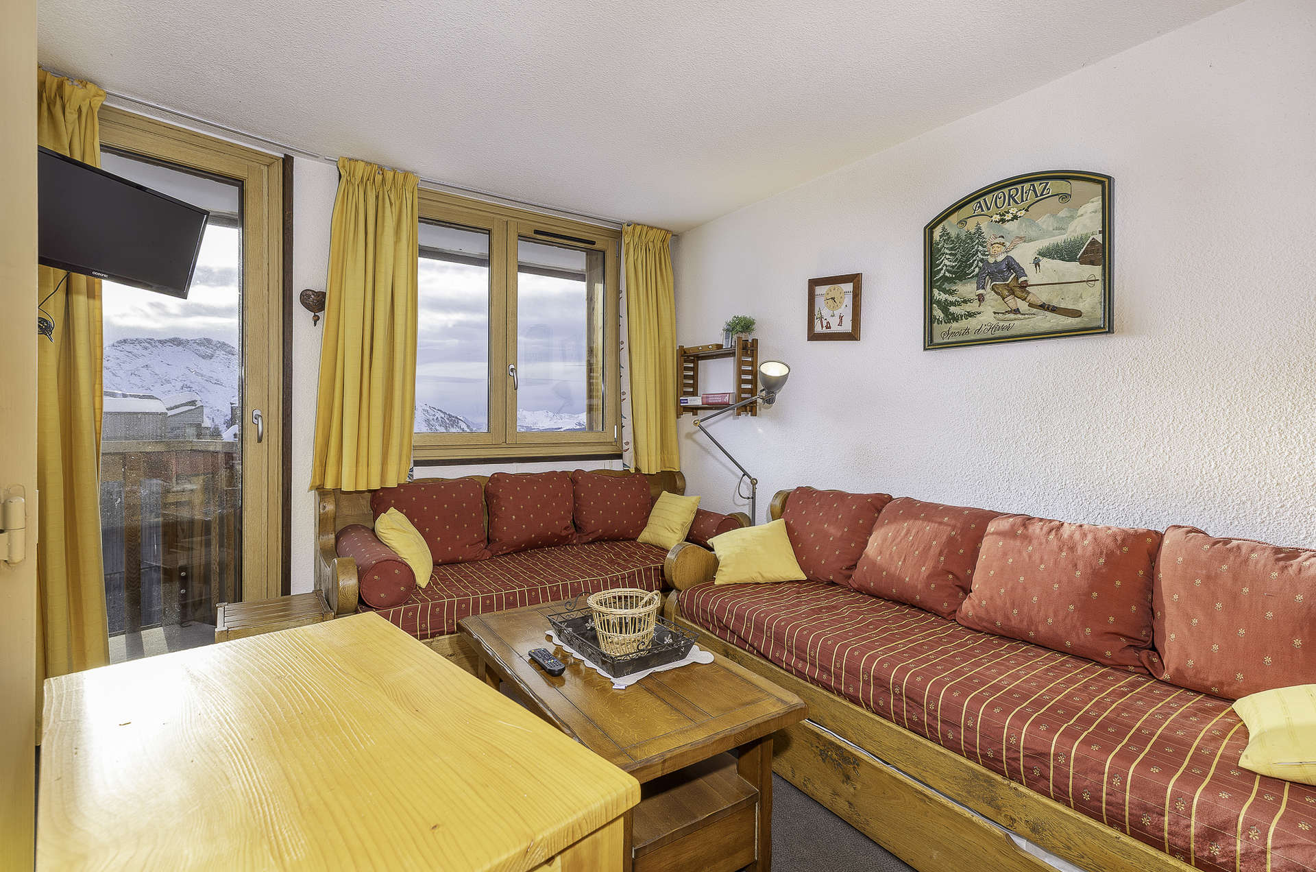 Lounge with red sofas and dining area in Apartment Alpages Standard, Avoriaz