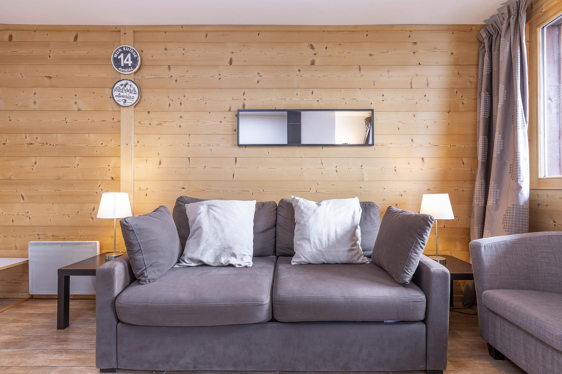 Lounge with grey sofa and wood-panelled walls in Apartment Araucarya, Avoriaz