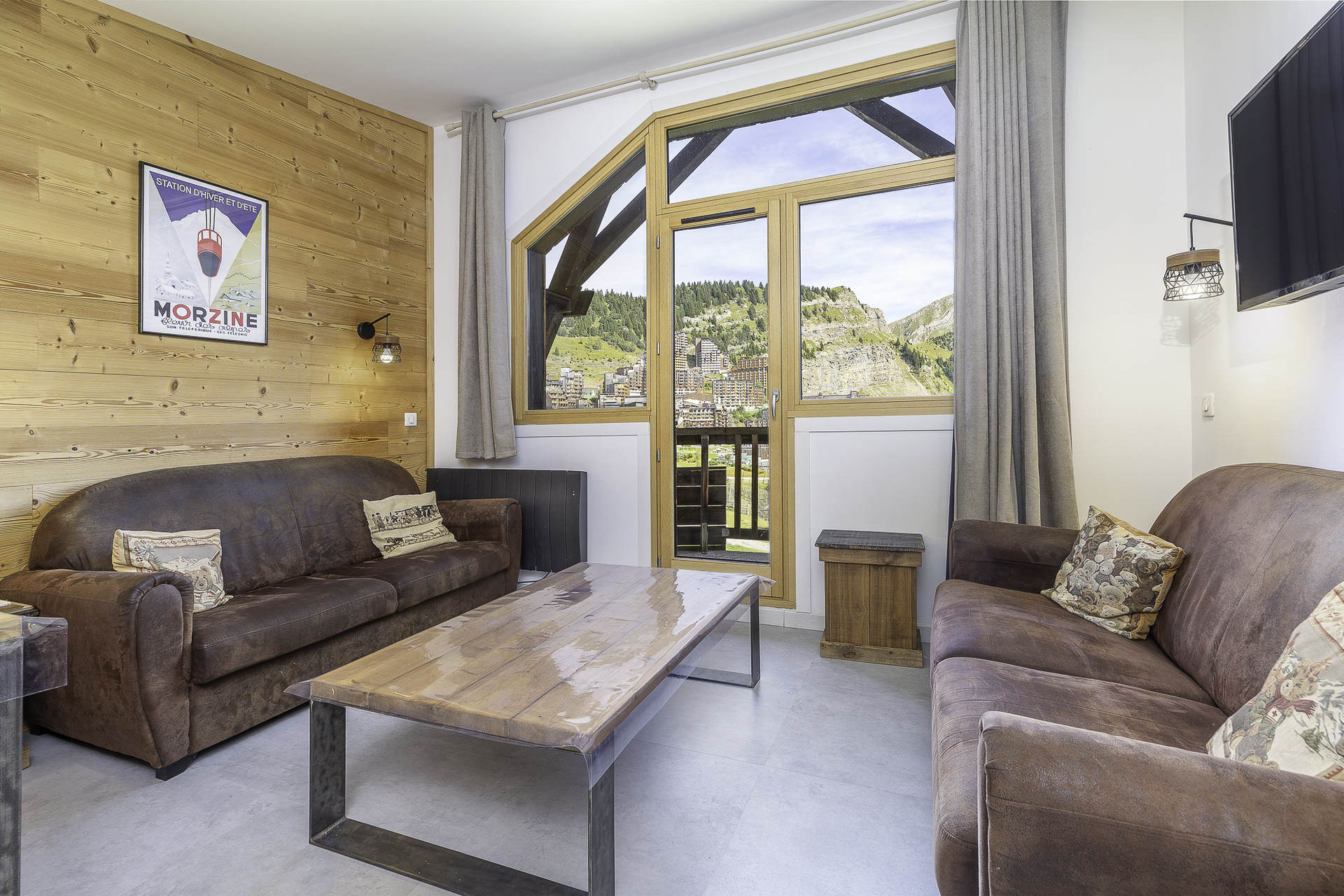 Lounge with leather sofas and mountain-view windows in Apartment Neva, Avoriaz
