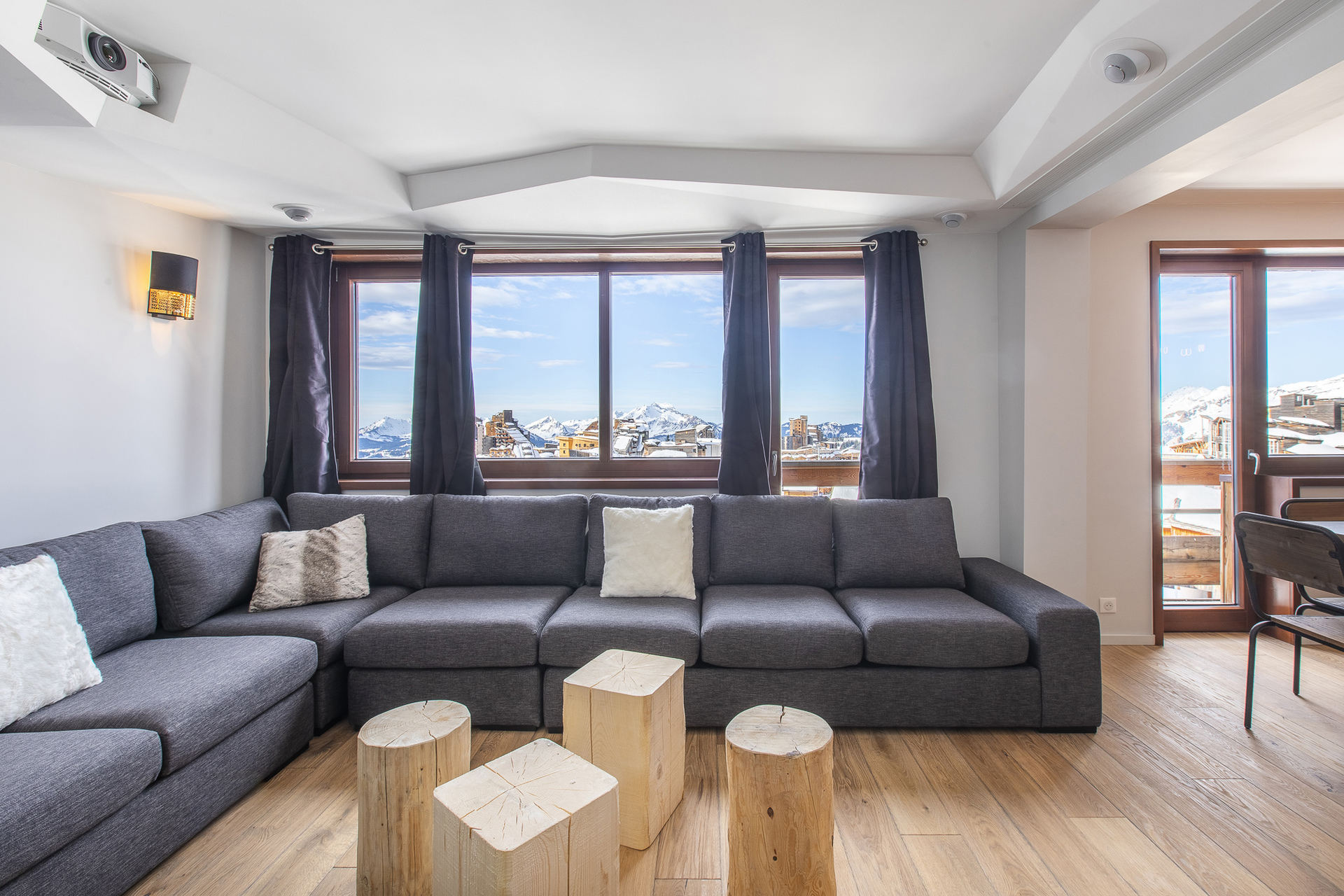 Lounge with large grey corner sofa and panoramic windows in Apartment Alpages Duplex, Avoriaz