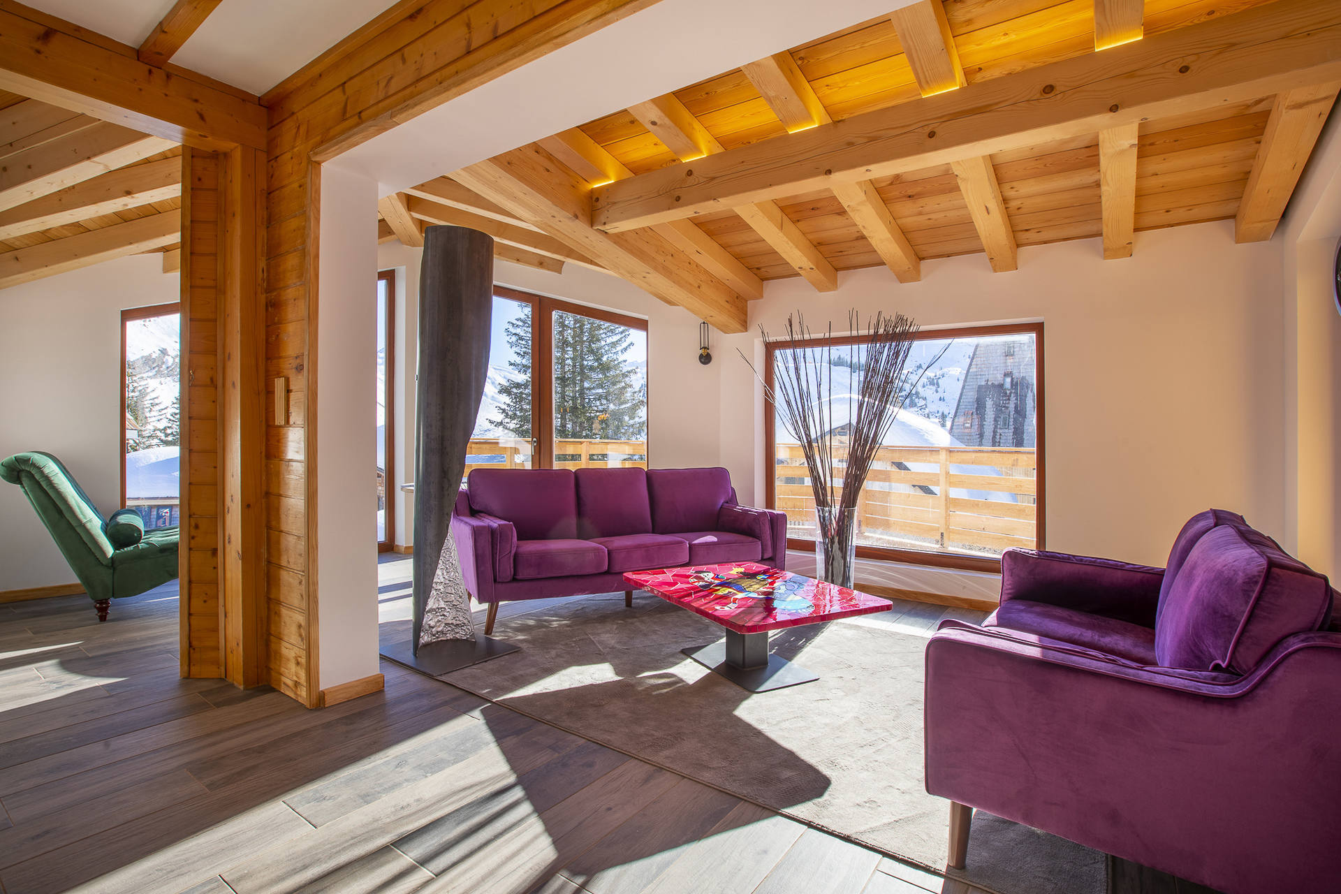Lounge with purple sofas and large windows in Chalet Arkor, Avoriaz