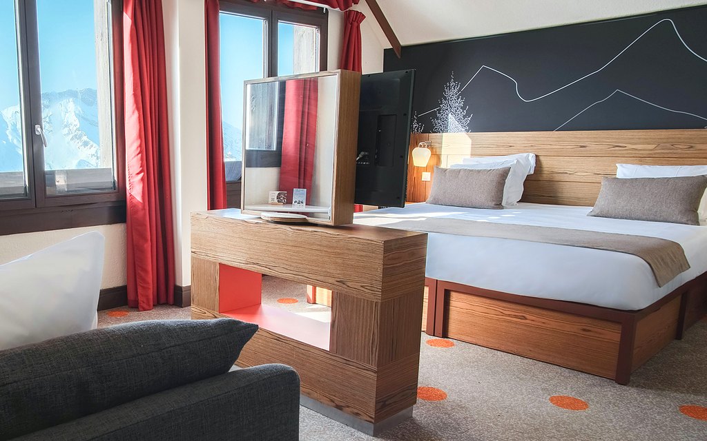 Family room with double bed, sofa and mountain views