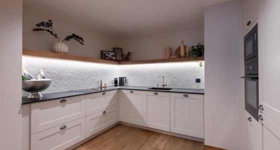 Fully equipped kitchen with white cabinets and built-in oven in Apartment Abeille, Morzine