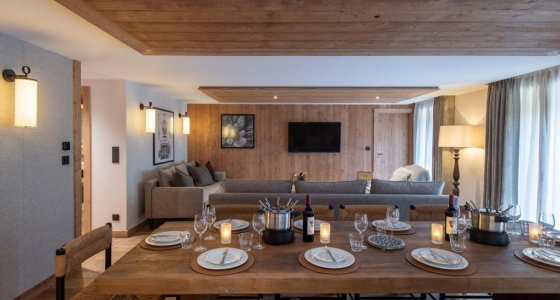 Dining table laid for dinner with lounge area behind in Apartment Chamossière, Morzine