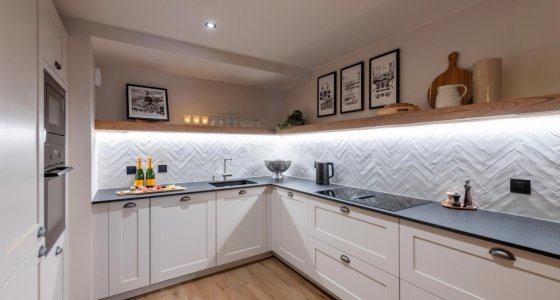 L-shaped kitchen with built-in oven and framed prints in Apartment Le Stade, Morzine