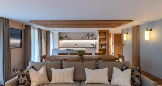 Grey sofa and long dining table in the open-plan living space in Apartment Chamossière, Morzine