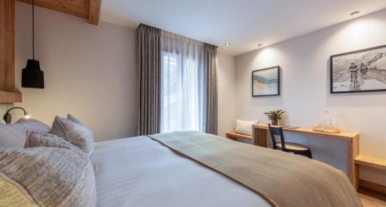 Bedroom with double bed and writing desk in Apartment Abeille, Morzine