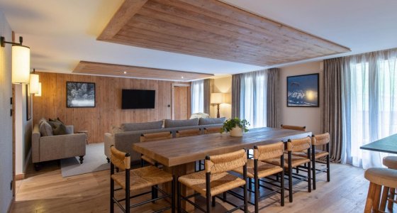 Open-plan dining and lounge area under a timber ceiling in Apartment Chamossière, Morzine