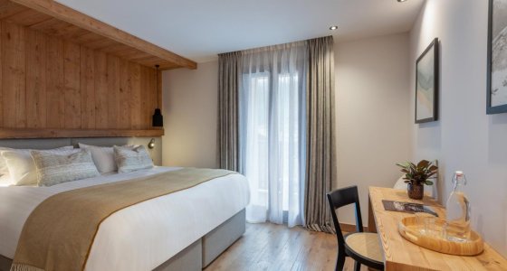 Bedroom with double bed and desk by the window in Apartment Abeille, Morzine