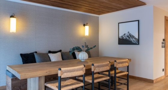 Dining table with rush-seat chairs and framed mountain print in Apartment Le Stade, Morzine