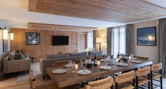 Long dining table, sofa and TV in the open-plan living space in Apartment Chamossière, Morzine