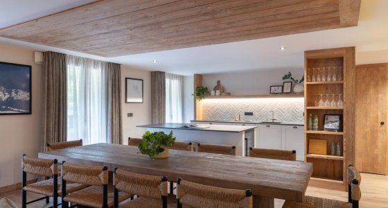 Dining table with kitchen and shelving behind in Apartment Chamossière, Morzine