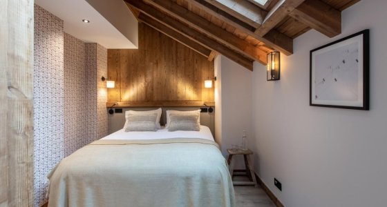 Bedroom with timber feature wall, skylight and framed print in Apartment Le Stade, Morzine