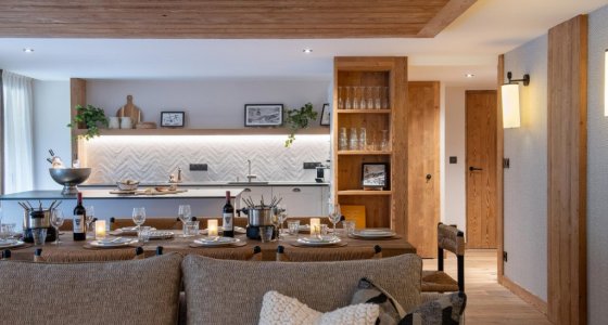 Dining table and kitchen with sofa cushions in the foreground in Apartment Chamossière, Morzine