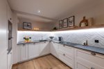 L-shaped kitchen with built-in oven and framed prints in Apartment Le Stade, Morzine
