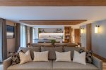 Grey sofa and long dining table in the open-plan living space in Apartment Chamossière, Morzine
