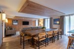 Open-plan dining and lounge area under a timber ceiling in Apartment Chamossière, Morzine