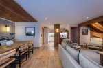 Open-plan living and dining space with long wooden table in Apartment Le Stade, Morzine