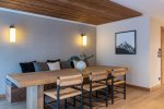 Dining table with rush-seat chairs and framed mountain print in Apartment Le Stade, Morzine