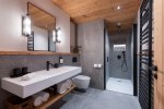 En-suite shower room with long white basin and walk-in shower in Apartment Abeille, Morzine