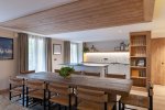 Dining table with kitchen and shelving behind in Apartment Chamossière, Morzine