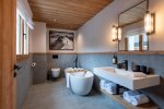 Bathroom with free-standing bath and long white basin in Apartment Abeille, Morzine