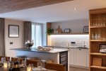 Kitchen island with dining table and bookshelves in Apartment Chamossière, Morzine