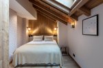 Bedroom with timber feature wall, skylight and framed print in Apartment Le Stade, Morzine