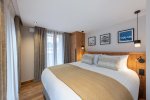 Double bedroom with cream bed runner and curtained window in Apartment Chamossière, Morzine
