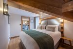 Double bedroom with green bed runner and warm timber details in Apartment Chamossière, Morzine