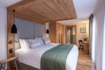 Bedroom with timber headboard wall and green bed runner in Apartment Chamossière, Morzine
