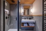 Shower room with glass-screened shower and basin in Apartment Chamossière, Morzine