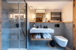 Modern shower room with glass shower, basin and heated towel rail in Apartment Chamossière, Morzine