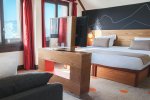 Family room with double bed, sofa and mountain views