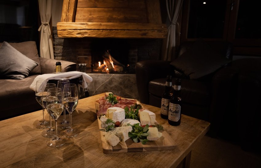 canapes around a log fire in ski chalet in Morzine